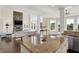 Open-concept living room with large windows, stone fireplace, and kitchen island at 3715 Kendall Wood Dr, Carmel, IN 46032