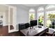 Office space features dark wood floors, white trim, arched windows providing natural light, and gray walls at 3715 Kendall Wood Dr, Carmel, IN 46032