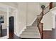 Inviting foyer with a staircase featuring wood and iron banisters and carpeted steps at 3715 Kendall Wood Dr, Carmel, IN 46032