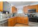 Functional kitchen featuring stainless steel appliances, stone backsplash, and wood cabinets at 377 Van Buren St, Greenfield, IN 46140