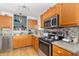 Functional kitchen featuring stainless steel appliances, stone backsplash, and wood cabinets at 377 Van Buren St, Greenfield, IN 46140