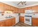 Bright kitchen featuring wood cabinets, white countertops, appliances, and laminate floors at 3818 Gray Pond Ct, Indianapolis, IN 46237