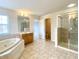 Bathroom featuring tile floor, soaking tub, double vanities, large mirrors, and a separate walk-in shower at 3926 Castle Rock Dr, Zionsville, IN 46077