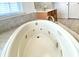 Close up of a bathroom jacuzzi tub with tile surround and a wall-mounted chrome faucet fixture at 3926 Castle Rock Dr, Zionsville, IN 46077