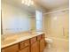 Well-lit bathroom featuring a double vanity, warm wood cabinets, and shower-tub combo, designed for comfort and convenience at 3926 Castle Rock Dr, Zionsville, IN 46077