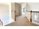Carpeted hallway with white wood banister, gray walls, and view to a room with lilac-colored curtains at 3926 Castle Rock Dr, Zionsville, IN 46077