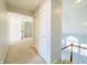 Bright hallway featuring neutral carpet, light gray walls, and a staircase with white balusters at 3926 Castle Rock Dr, Zionsville, IN 46077