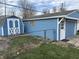 A blue one-car garage and matching shed with white trim sit on a fenced in lot with a tidy lawn at 4121 Fletcher Ave, Indianapolis, IN 46203