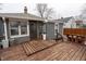 Backyard features a wooden deck and small grey vinyl-sided house with brown trim at 4711 East 21St St, Indianapolis, IN 46218