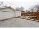 View of detached garage, paved patio area with table, and wooden privacy fence at 4711 East 21St St, Indianapolis, IN 46218