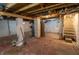Spacious unfinished basement with exposed beams, mechanicals, concrete foundation, and access to stairs at 4711 East 21St St, Indianapolis, IN 46218