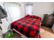 Bedroom with a red and black bedspread, dark dresser, sheer curtains, and a carpet floor at 4711 East 21St St, Indianapolis, IN 46218