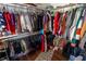 Walk-in closet with wood floors, hanging rods, shelves, and a full assortment of clothes at 4711 East 21St St, Indianapolis, IN 46218