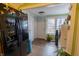 View of the entryway with a black refrigerator, front door, washer, dryer, and wood-look vinyl floors at 4711 East 21St St, Indianapolis, IN 46218
