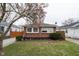 Cozy brick home featuring a well-maintained lawn and a mature tree with blossoming flowers in a peaceful residential neighborhood at 4711 East 21St St, Indianapolis, IN 46218