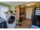 Galley kitchen with wood cabinets, washer and dryer hookups, updated vinyl floors, and green painted walls at 4711 East 21St St, Indianapolis, IN 46218