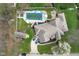 Aerial view of a home featuring a pool, deck, fenced yard, mature trees, and private driveway at 4808 N Camelot Dr, Muncie, IN 47304