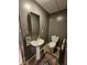 Compact bathroom with pedestal sink, medicine cabinet, and a neutral color palette, maximizing space and functionality at 4808 N Camelot Dr, Muncie, IN 47304