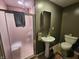 Small bathroom with step-in shower, pedestal sink, and minimal decor, designed for convenience and efficient use of space at 4808 N Camelot Dr, Muncie, IN 47304