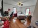 Bedroom with hardwood flooring, two windows, ceiling fan, and desk workspace at 4808 N Camelot Dr, Muncie, IN 47304