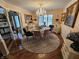 Chandelier-lit dining area with circular rug, glass table, and traditional decor, offering a refined dining experience at 4808 N Camelot Dr, Muncie, IN 47304