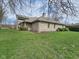 A long shot of the exterior of the home with a brick exterior and a large grassy front lawn at 4808 N Camelot Dr, Muncie, IN 47304