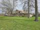 Charming single-story brick home featuring mature trees and a well-manicured lawn at 4808 N Camelot Dr, Muncie, IN 47304