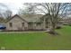 Lovely brick home featuring a manicured lawn, mature trees, and a welcoming facade at 4808 N Camelot Dr, Muncie, IN 47304