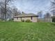A long shot of the exterior of the home with a brick exterior and a large grassy backyard at 4808 N Camelot Dr, Muncie, IN 47304