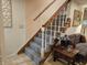Carpeted staircase with wooden handrail and white spindles, provides access to upper levels, next to cozy sofa at 4808 N Camelot Dr, Muncie, IN 47304