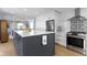 Open kitchen with island seating, featuring white countertops and stainless appliances at 490 W Walnut St, Zionsville, IN 46077