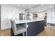 Kitchen island with seating, white cabinets, and stainless steel appliances at 490 W Walnut St, Zionsville, IN 46077