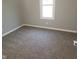 Bedroom featuring neutral gray walls, a window for natural light, and cozy carpeting at 509 N Home Ave, Mooresville, IN 46158