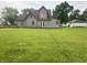 Rear exterior view of the home with a spacious grassy yard and garage at 554 N Tacoma Ave, Indianapolis, IN 46201