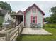 This cute house features gray siding, red trim, a wooden ramp, and a patio with outdoor seating at 554 N Tacoma Ave, Indianapolis, IN 46201
