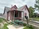 Charming home with gray siding, red trim, covered porch, wooden ramp, and picnic table at 554 N Tacoma Ave, Indianapolis, IN 46201