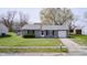 Single-story home featuring a well-manicured lawn, attached garage, and a classic gray exterior at 6124 Dry Den Ct, Indianapolis, IN 46221