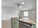 Kitchen island with stainless steel sink, green cabinets, dishwasher, and unique patterned countertop at 6124 Dry Den Ct, Indianapolis, IN 46221