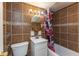 Bathroom featuring tiled walls, vanity, toilet, and shower/tub combination with floral shower curtain at 6340 Bluebell Ct, Indianapolis, IN 46224