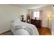 Cozy bedroom with hardwood floors, a dresser, and natural light from the window at 6340 Bluebell Ct, Indianapolis, IN 46224