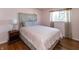 Stylish bedroom featuring a queen-sized bed, hardwood floors, and a lamp on the nightstand at 6340 Bluebell Ct, Indianapolis, IN 46224