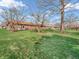 Spacious backyard with a brick home, mature trees, and green lawn, providing ample space for outdoor activities at 641 Beech W Dr, Plainfield, IN 46168