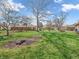 Large backyard with mature trees and green lawn surrounding a charming brick home at 641 Beech W Dr, Plainfield, IN 46168
