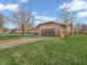 Brick home featuring an attached two-car garage with a wide driveway and well-maintained green lawn at 641 Beech W Dr, Plainfield, IN 46168