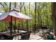 A back deck features an outdoor table, seating, and views of the surrounding woods in the backyard at 649 E Country Ln, Martinsville, IN 46151