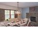 Comfortable dining area with stone fireplace, a unique lighting fixture, and lots of natural light at 649 E Country Ln, Martinsville, IN 46151