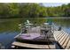 Pontoon boat rests on a dock, offering direct water access with seating in a serene lake setting at 649 E Country Ln, Martinsville, IN 46151