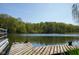 Lakeside view showcasing a wooden dock with greenery, providing serene access to the calm water and lush trees at 649 E Country Ln, Martinsville, IN 46151