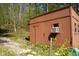 Wood-sided shed with an air conditioning unit, located on a wooded property with a gravel path at 649 E Country Ln, Martinsville, IN 46151
