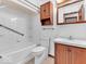White tiled bathroom includes tub, toilet, and a wood vanity at 66 Coronado Rd, Indianapolis, IN 46234